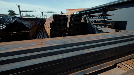 large industrial warehouse of metal products, pipes in the open air. metal steel angle, channels on the site for sale