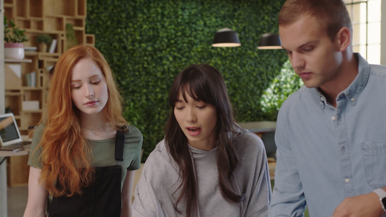 다민족 사업가 들 이 창의적 인 팀 리더 여성 들 이 아이디어 를 공유 하고 협력 하는 것 을 즐기는 동료 들 이 사무실 에서 노트북 을 사용 하여 함께 일 하는 것