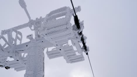 pov ride on chairlift passing frozen supporting tower in skrzyczne, poland