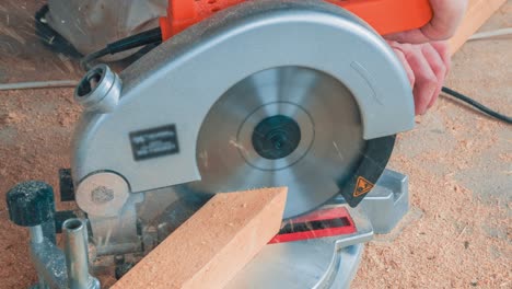 carpenter using circular saw for cutting wooden boards