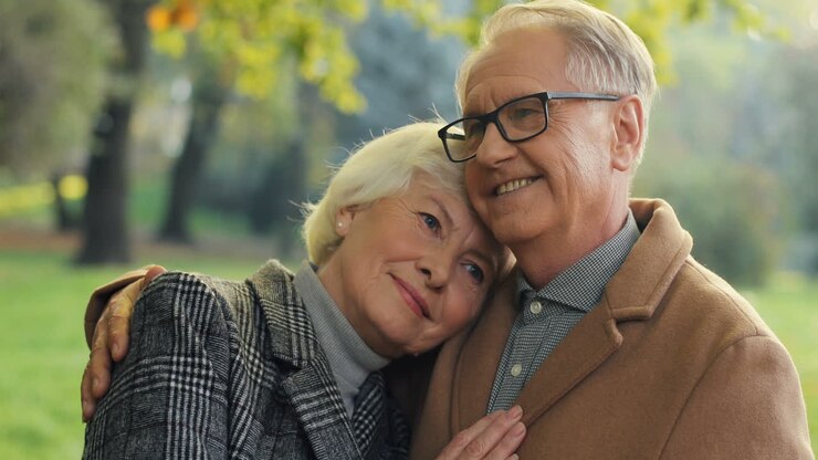 Elderly Married Couple Hugging In The Autumn Park