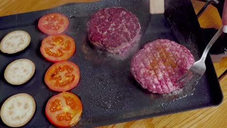 utensil flipping burgers on spacious plancha grill