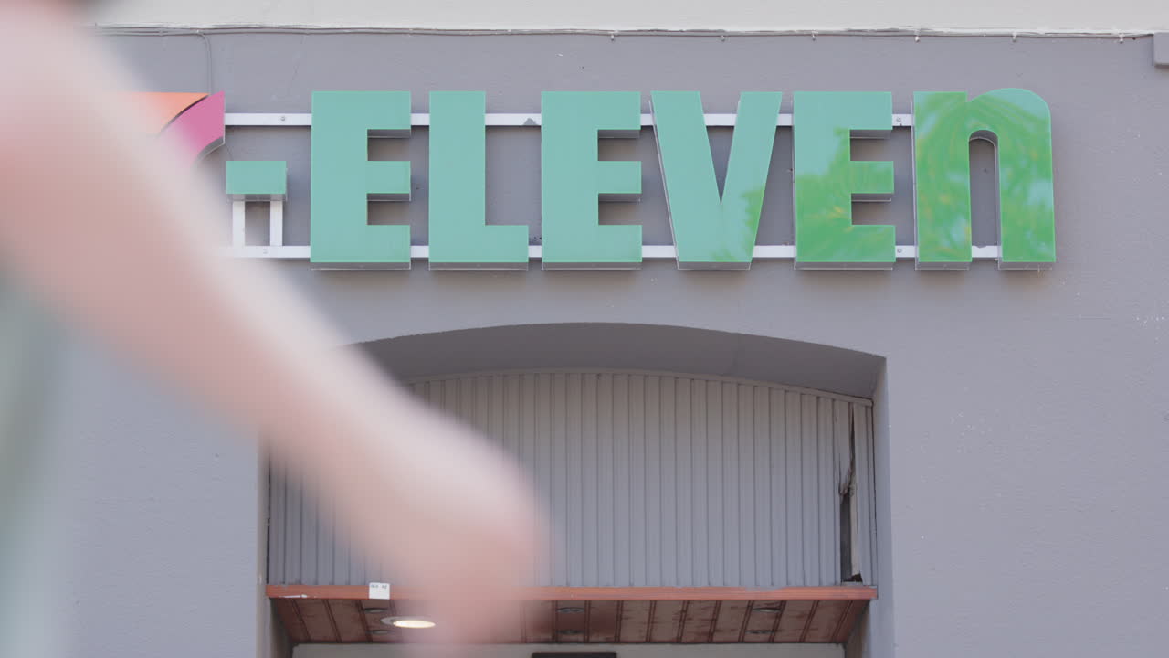 Pedestrians pass a 7 Eleven store front in Oslo, Norway
