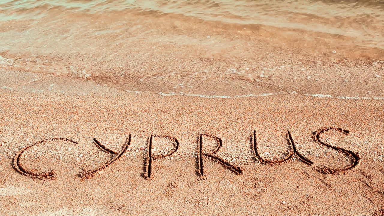 Inskriptionen Cypern i sanden. Fotografering på stranden