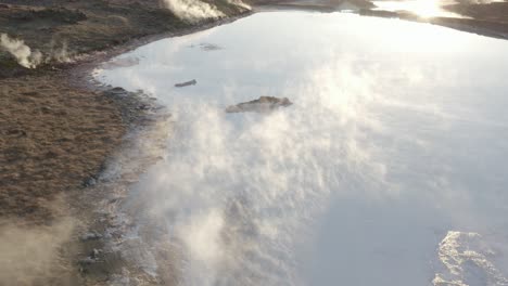 steam rises from acidic volcanic lake in iceland, evaporation process