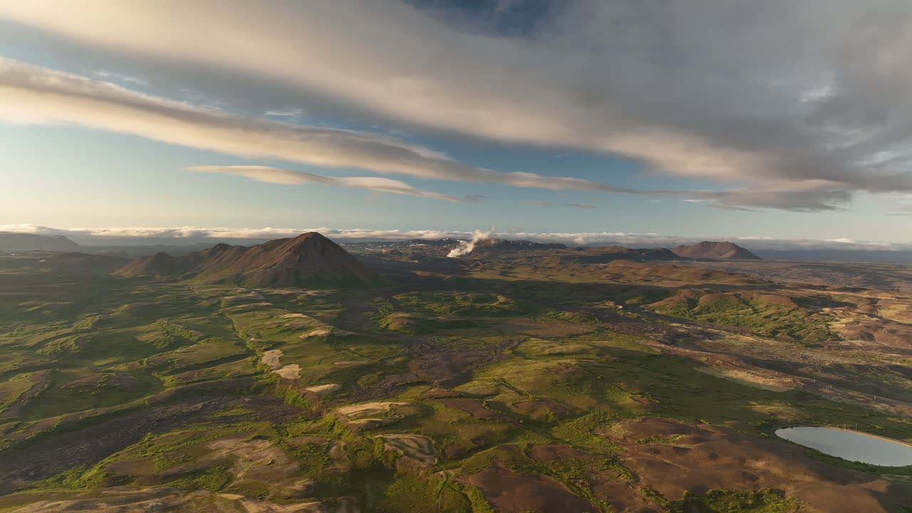 puesta de sol sobre las colinas y montañas volcánicas con planta de energía geológica