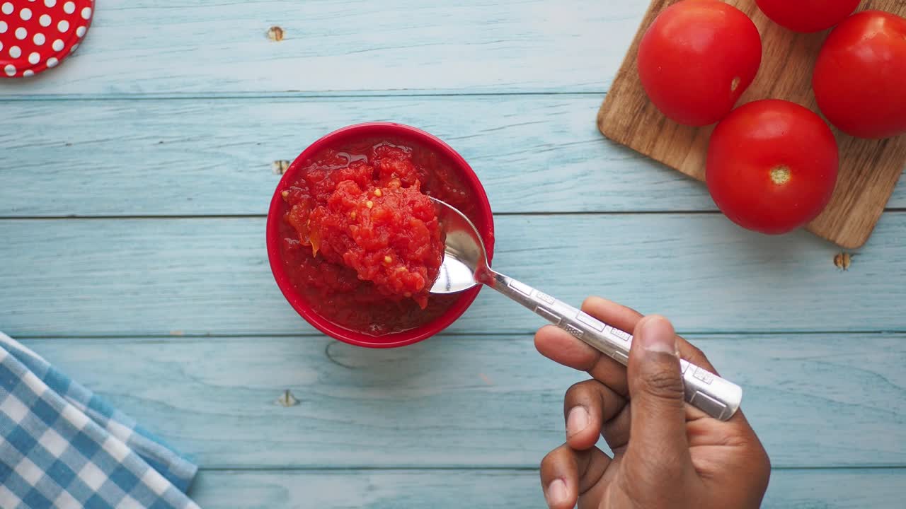 Hand Scooping Tomato Sauce
