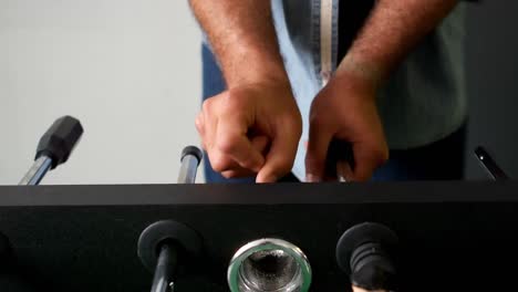 Man-playing-table-football-game