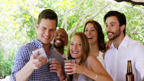 grupo de amigos tomando selfies con el teléfono móvil en el mostrador de la barra
