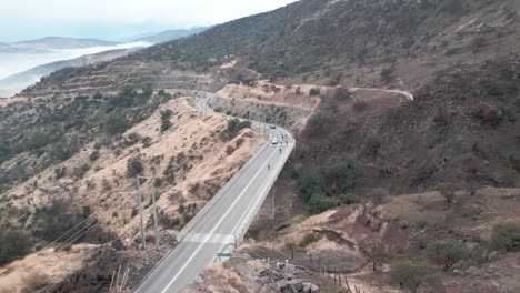 cyclists-pedaling-over-a-hill-in-the-municipality-of-Lo-Barnechea,-Chile