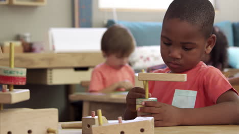 montessori school pupils work at desk with wooden building set