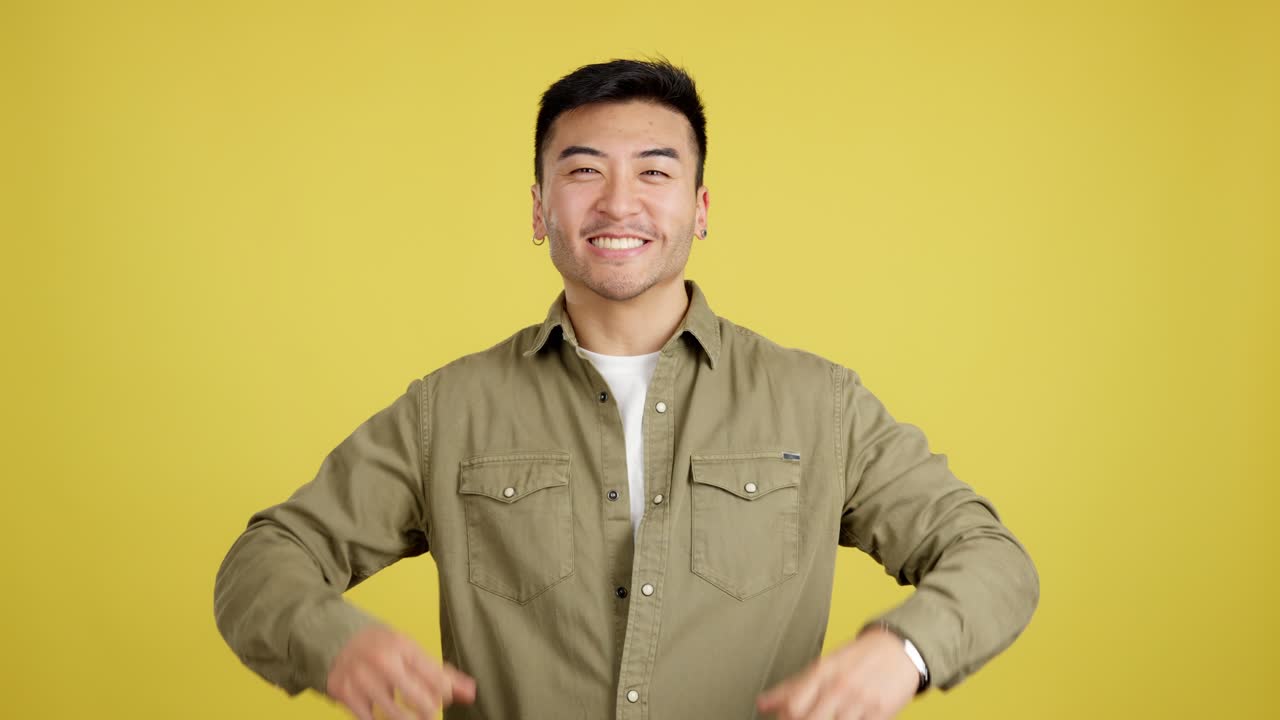 Excited Asian man celebrating on a yellow background