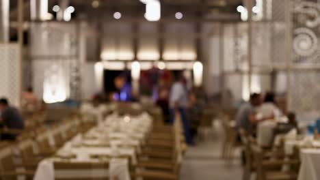 un bullicioso restaurante con clientes y personal, con iluminación cálida y decoración elegante, capturado en un estilo dinámico y borroso