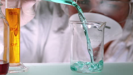 científico vertiendo líquido azulado en un vaso