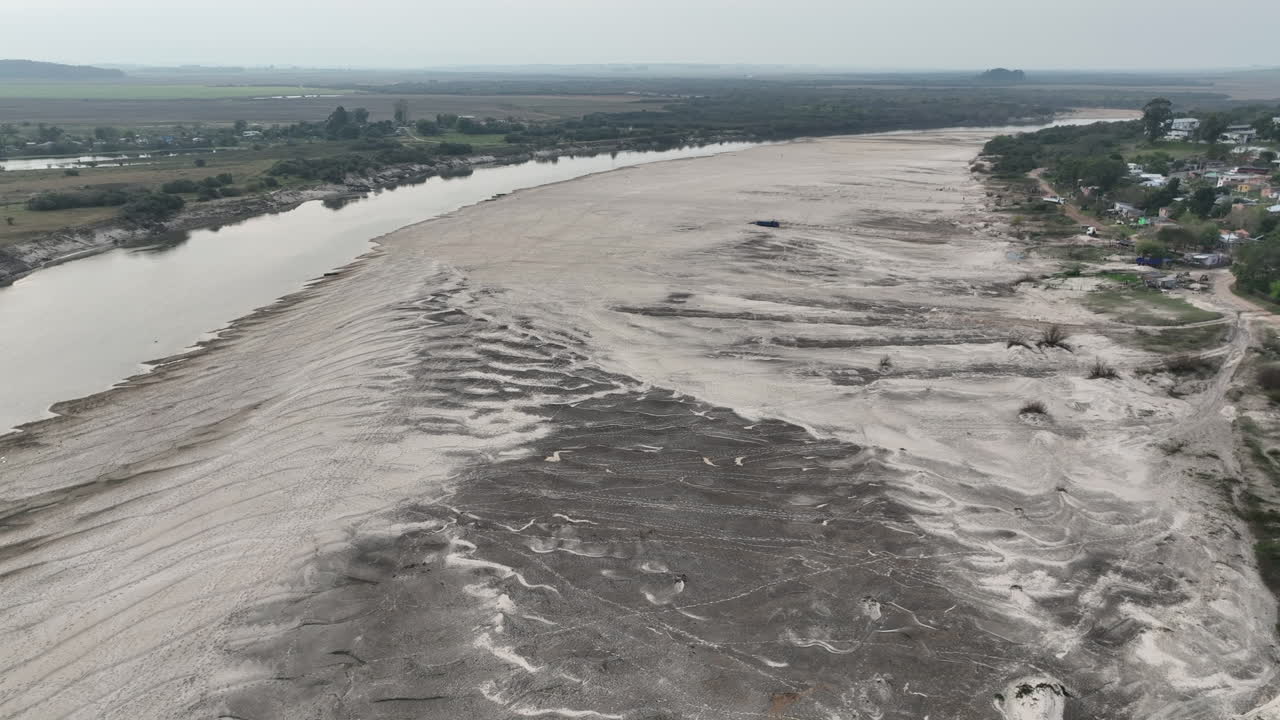 Movimento cinematografico aereo lento con carrellata verticale verso il basso che cattura la texture intricata e i modelli naturali della sabbia bianca sulla spiaggia di Areias Brancas a Rosario do Sul, Brasile