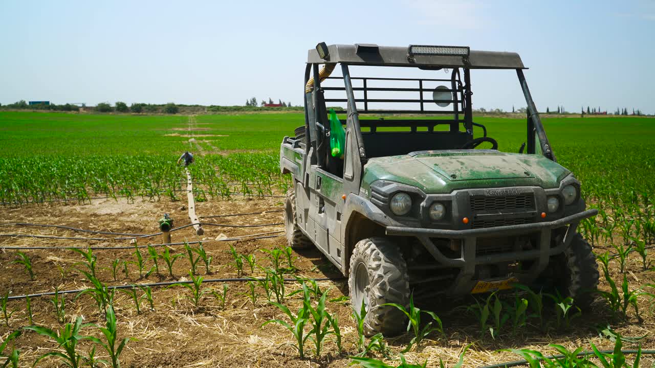 un guardabosques está estacionado en un campo de maíz con riego por goteo