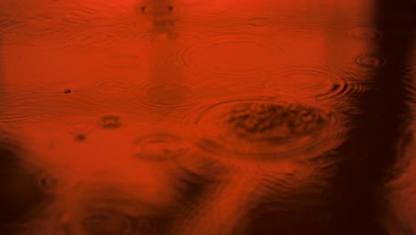 agua en movimiento lento gotas de lluvia cayendo sobre el agua sobre el suelo, hermosa superficie azul onda papel tapiz abstracto, patrón de círculo en el suelo, salpicaduras de gota de lluvia caendo y goteando en el suelo mojado