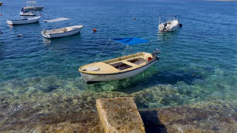 Kleines-Friedliches-Motorboot,-Das-In-Einem-Sauberen-Und-Klaren-Meer-Gefesselt-Ist-Und-Schwimmt