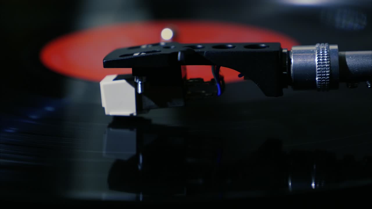 Closeup needle on spinning vintage vinyl record on turntable slow motion
