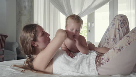 baby lying on mom in bed