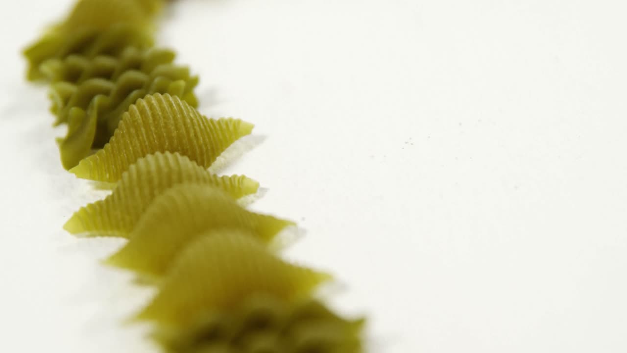 Various fusilli and conchiglie pasta on white background