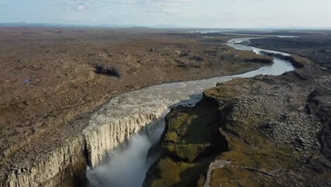 impressive aerial view of dettifoss, flowing into jökulsá á fjöllum river, carving its way through a basalt canyon in a breathtaking icelandic landscape, establishing shot