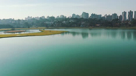 Parque-Barigui-Skyline-Gründungsaufnahme-In-Der-Nähe-Des-Wassers-Des-Sees-Drohne-Luftaufnahme,-Curitiba,-Paraná,-Brasilien