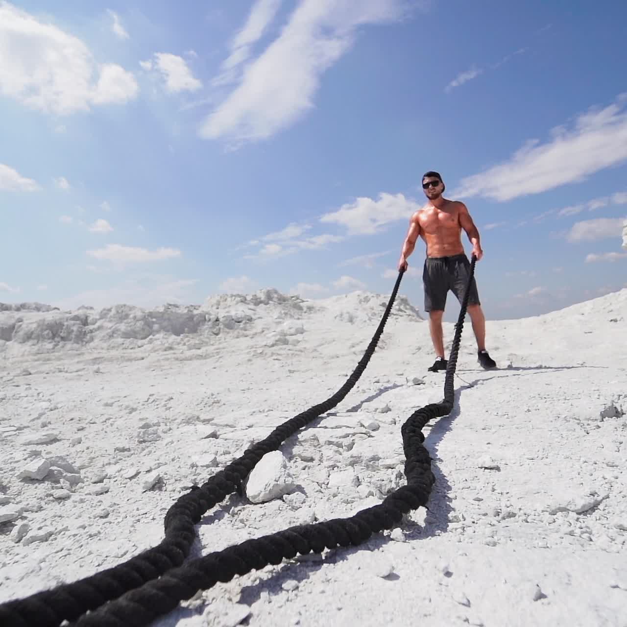 Bodybuilder exercising with battling ropes