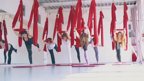 Damengruppe-übt-Aerial-Yoga-Warrior-Asana-Auf-Einem-Bein