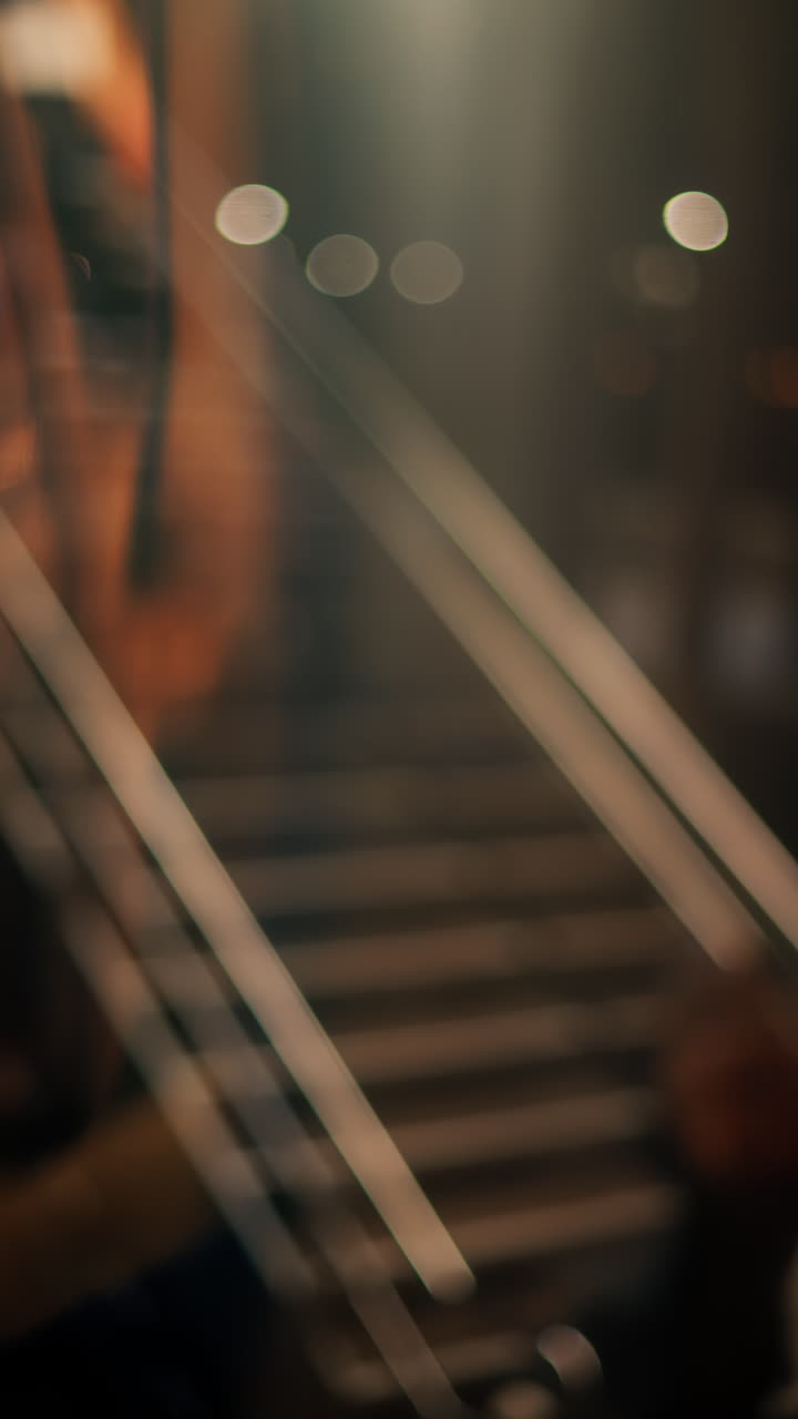 Visuale sfocata di persone che camminano sulle scale in una stazione ferroviaria. Verticale