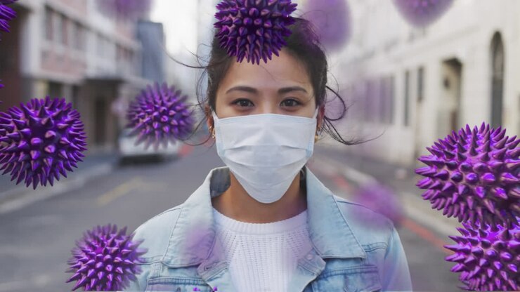 Animation af makro coronavirus Covid-19-celler, der spreder sig over en kvinde af blandet etnicitet, som bærer en ansigtsmaske.