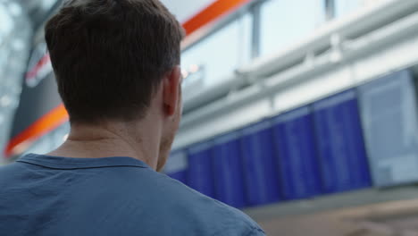 man checking flight information on timetable board at airport