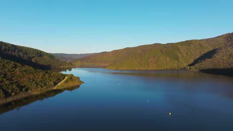 calm waters of encoro da ribeira, reservoir in pontes de garcía rodríguez, spain - aerial shot