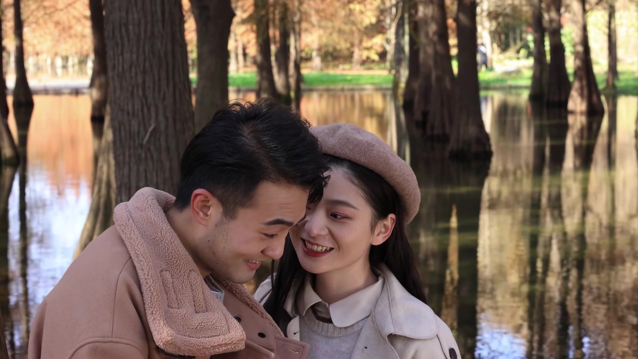 Pasangan muda yang tersenyum, ceria, dan aktif menikmati waktu di taman pertanian, menjalin hubungan yang baik, mengambil swafoto, dan melihat-lihat foto di alam terbuka yang tenang dengan nuansa romansa musim gugur, romantis dan masih saling mencintai.