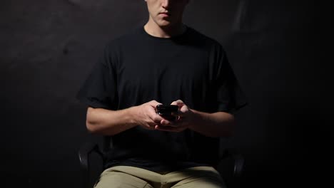 shot of a man sitting in a chair texting really quickly with his fingers