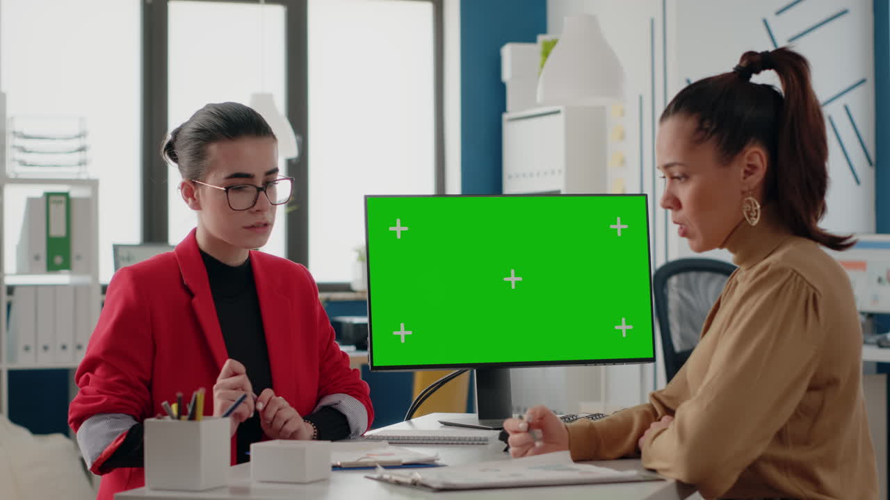 Women doing teamwork with isolated green screen on computer