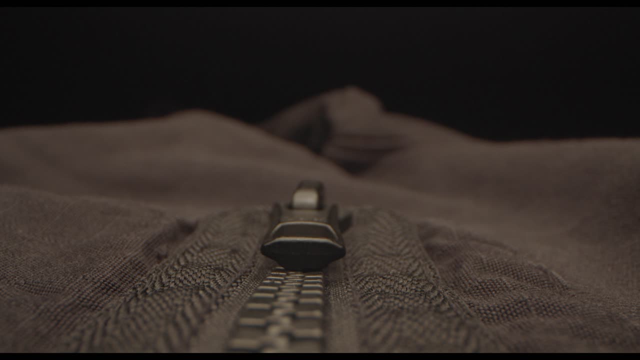 съемка движущимся объективом вдоль молнии черной куртки