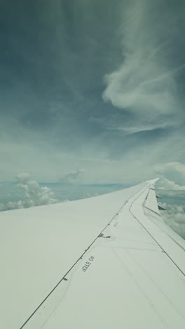 view from a plane window of the sky with the wing shot in vertical