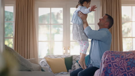 Adorable-Niña-Saltando-A-Los-Brazos-De-Su-Padre-Padre-Feliz-Atrapando-A-Su-Hija-Disfrutando-De-Un-Juego-Lúdico-En-Casa-Confianza-Familiar-4k