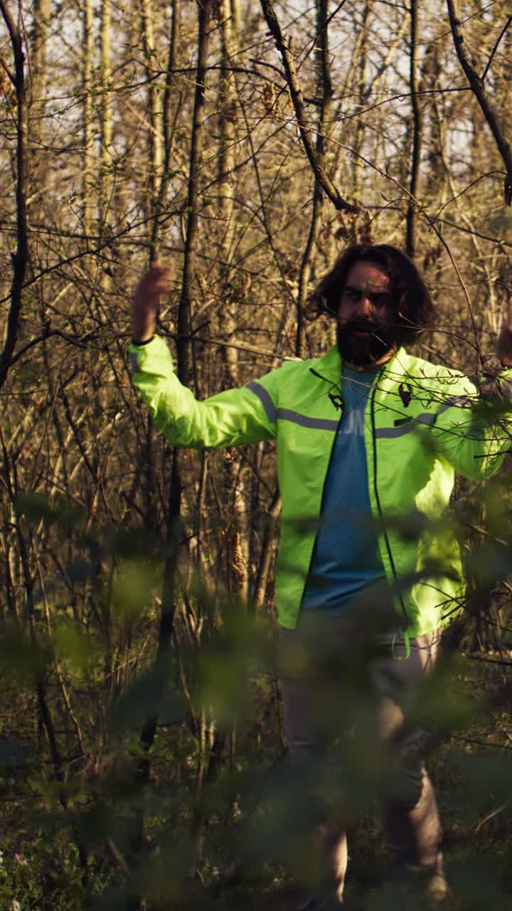 Man in Reflective Jacket Walking Through Dense Forest