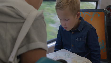 boy with mom looking at map in train