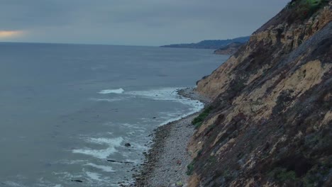 top down birds eye aerial view of the waves crashing on a rocky southern california beach