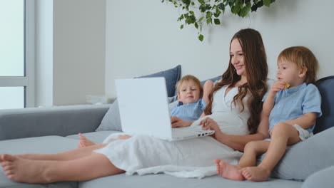 familia feliz madre, hijo niño jugar computadora portátil en casa