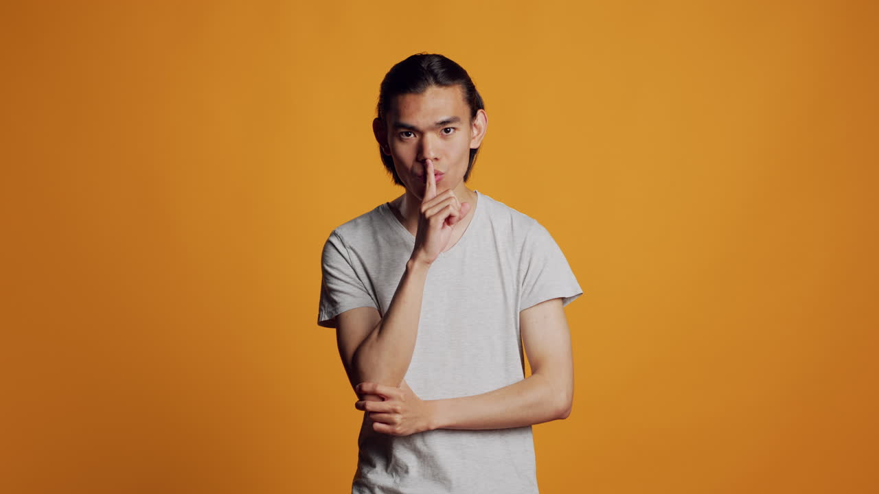 Male model doing mute silent gesture in studio