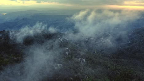 drone volando a través de las nubes y la niebla matutina en lo alto de la cordillera