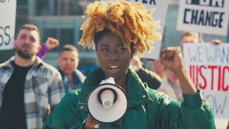 protestors with placards and megaphone on black lives matter demonstration march against racism