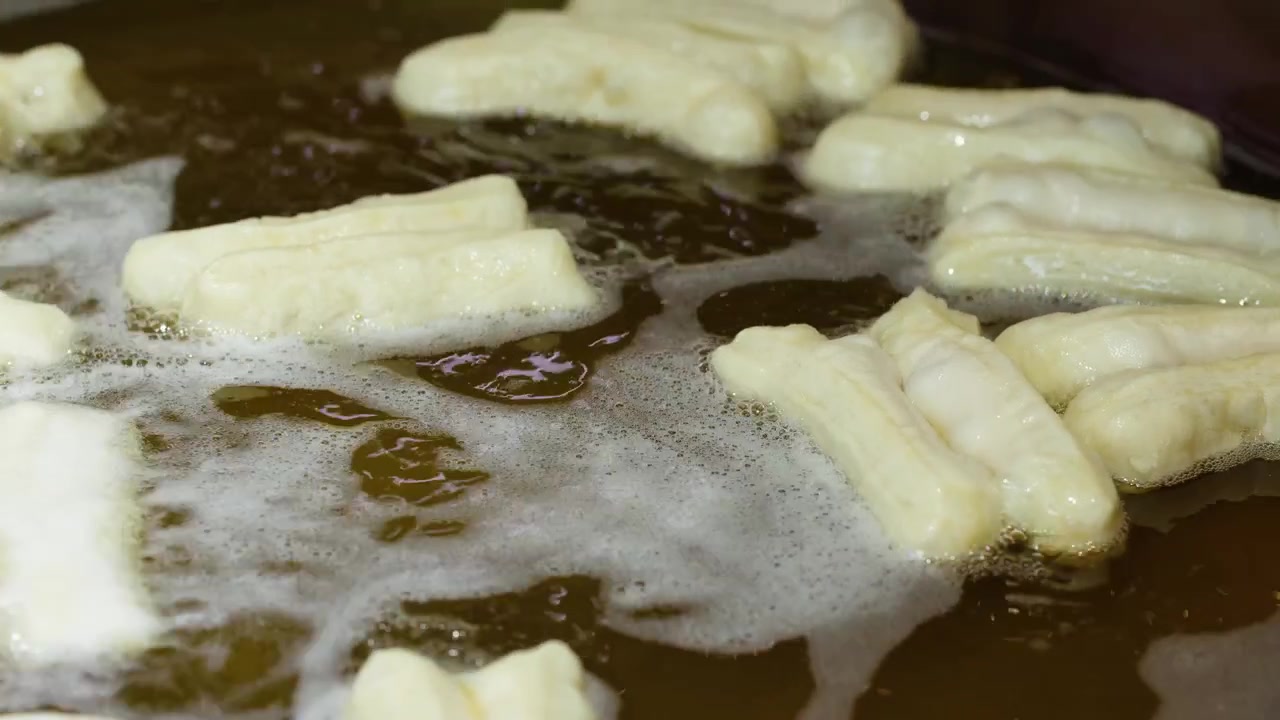 Deep Frying Youtiao Chinese Doughnuts in Hot Oil