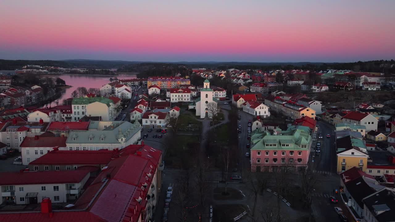 Calm orange pink sunset church Kyrka Strömstad Stromstadr Sweden aerial drone Sandelfjord Fjord small seaside town marina harbor Scandinavia Arctic Circle Skagerrak Baltic Sea Sverige forward motion