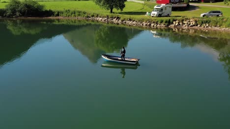 woman on the boat catches a fish on spinning in norway.