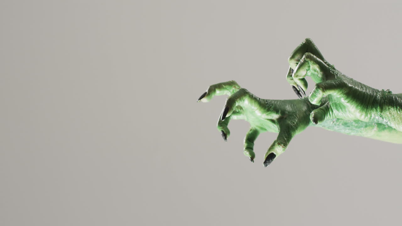 video de las manos del monstruo verde de halloween con espacio de copia en fondo gris